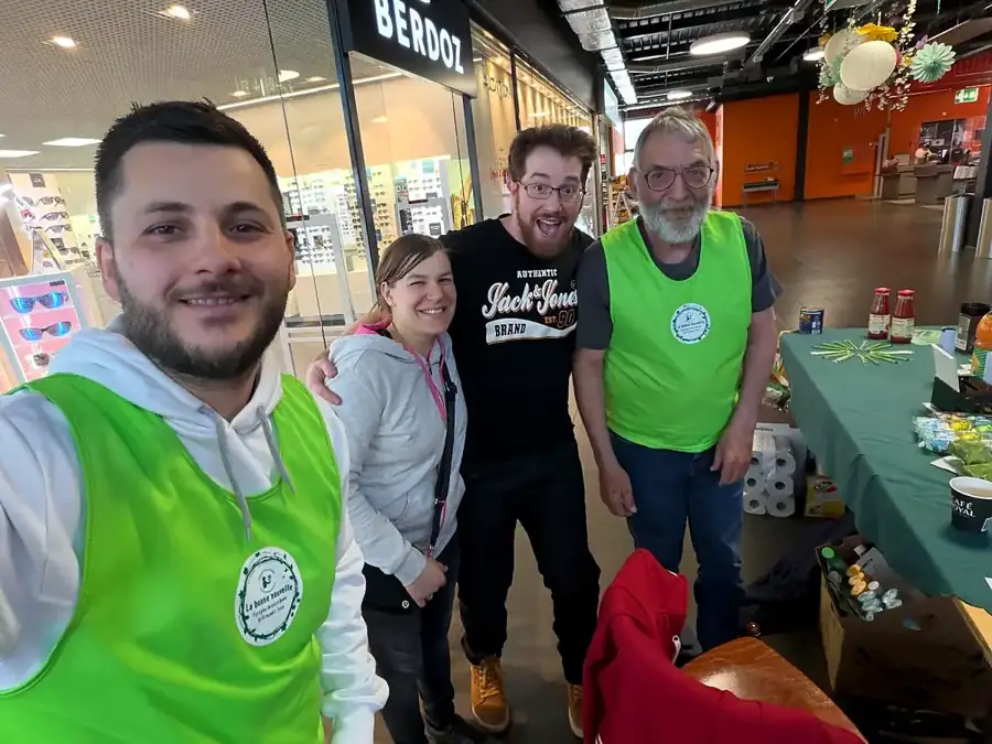 Quatre bénévoles souriants dans une galerie marchande
